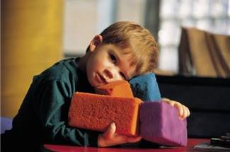 3 or 4 year old boy holding soft, multicolored sponge blocks
