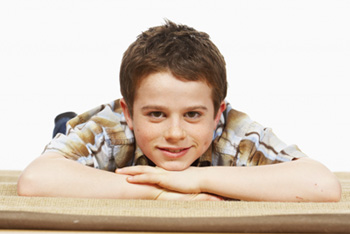 adolescent boy lying on stomach smiling