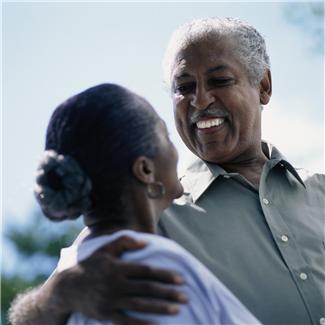 African American couple smiling at each other, approx. age 60