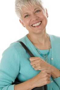 smiling lady with short white hair wearing teal sweater