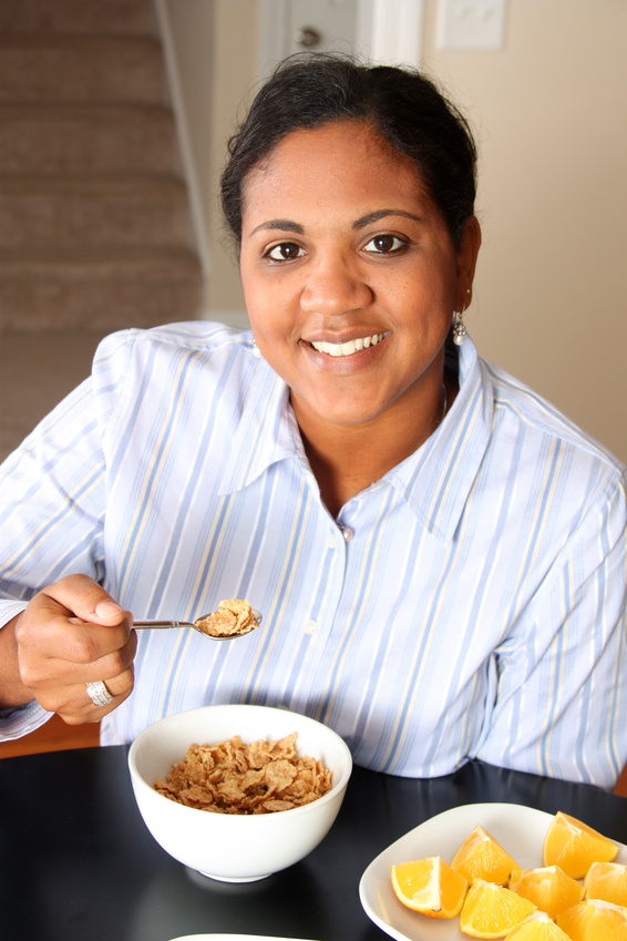 Latina lady eating cereal  and orange slices